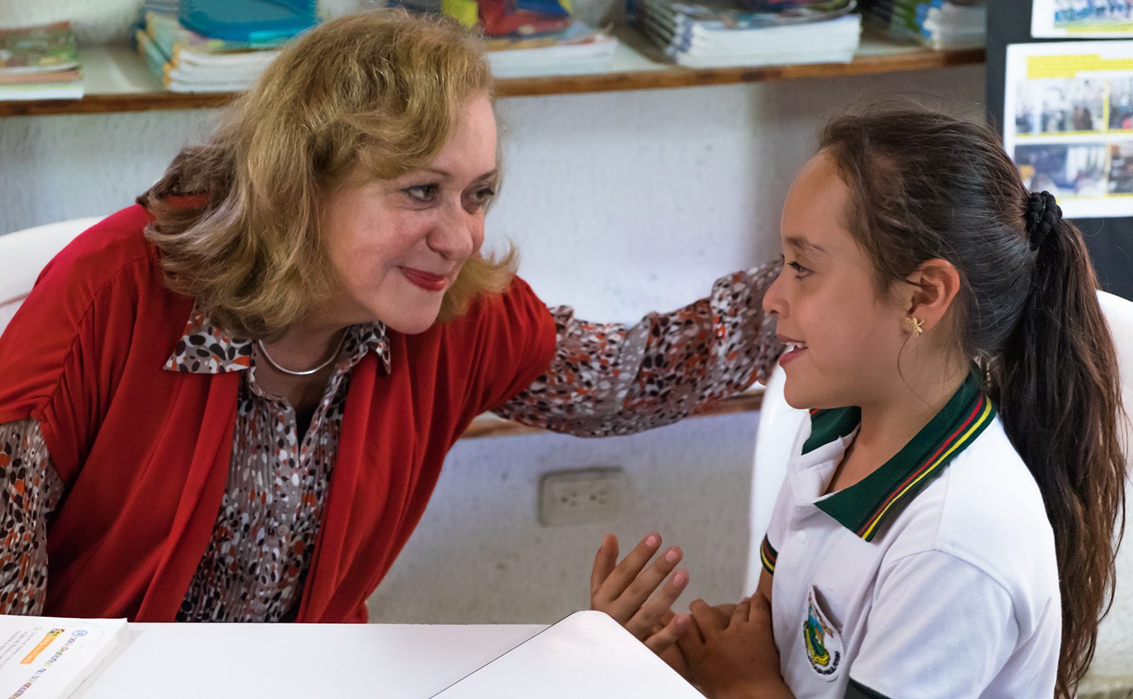 Vicky Colbert speaking with one of the young students at the Escuela Nueva school Sede Cabaña in rural Colombia, where kids from first through fifth grade all share a single classroom. (Credit: Jared Wade)