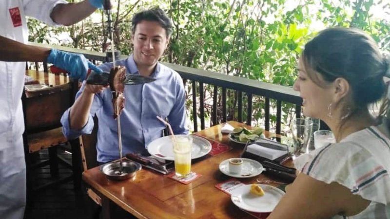 The mayor chowing down on a big beef as his wife looks on (photo: Twitter account of José Félix Lafaurie)