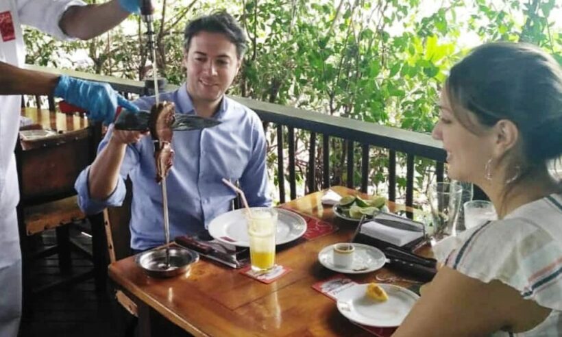 The mayor chowing down on a big beef as his wife looks on (photo: Twitter account of José Félix Lafaurie)