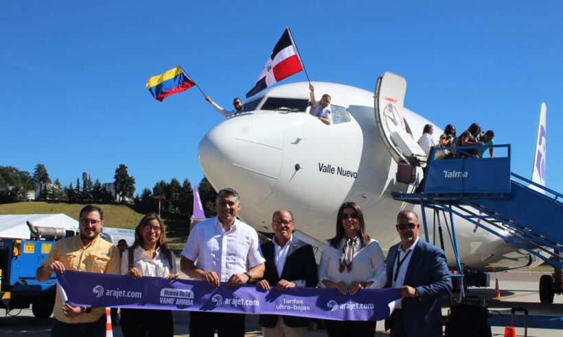 Arajet employees wave flags and take press photos to commemorate the launch of a new route from Medellin to Santiago, Dominican Republic.