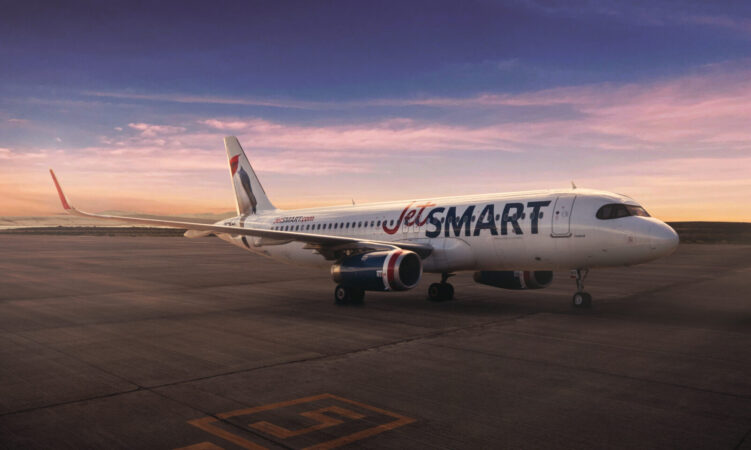 A JetSmart aircraft on the tarmac at sunset.