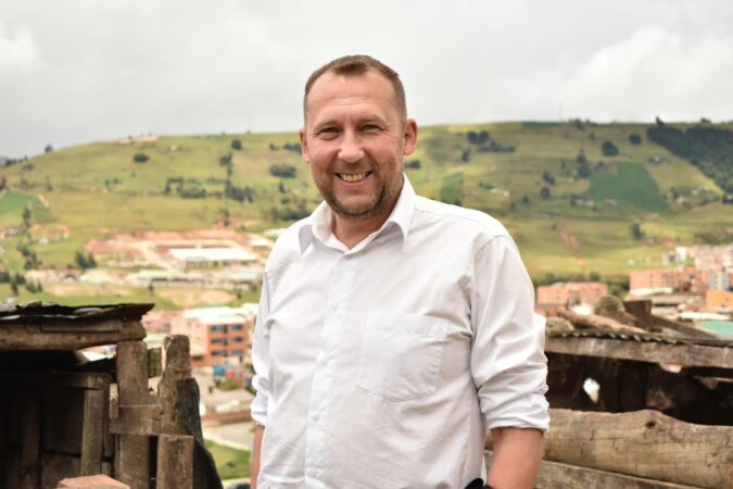 Mikhail Krasnov in front of a landscape in Tunja