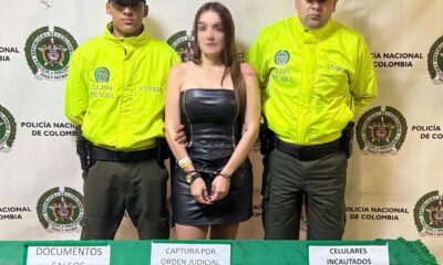 Front photo of the 'Scopolamine Queen of Lleras Park', handcuffed, with two police officers on each side