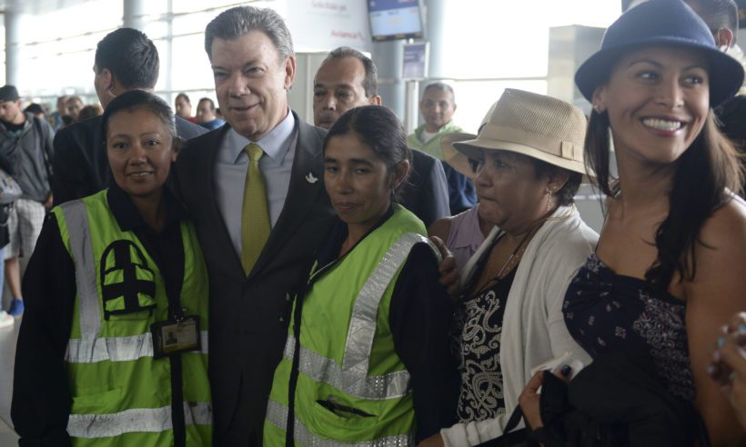 President Santos in Bogotá's El Dorado International Airport, flanked by 2 airport employees. Photo credit: Efraín Herrera