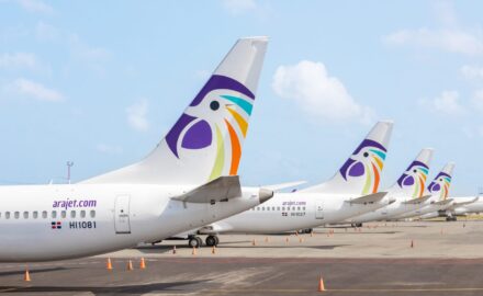 The tail of several Arajet planes at an airport