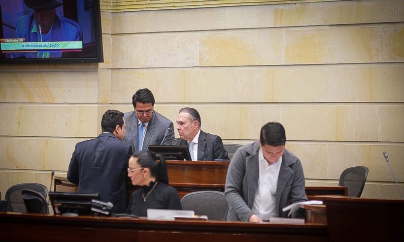 Senate President Efrain Cepeda, centre chair, discuss a bill with congressman in the chamber