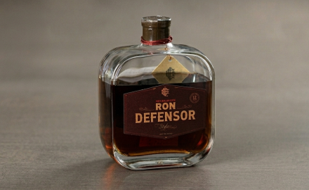 Bottle of Ron Defensor Style rum, 12-year aged, with a dark label and red cord around the neck