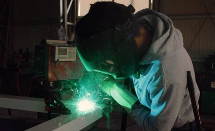 A welder doing construction work within a factory.