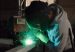 A welder doing construction work within a factory.