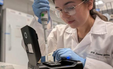 Colombian scientist Laura Gonzalez Garcia working in a laboratory, carefully using a pipette with specialized equipment while wearing a lab coat, gloves, and safety glasses. (Photo: Colombia Embassy US via Instagram)