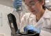 Colombian scientist Laura Gonzalez Garcia working in a laboratory, carefully using a pipette with specialized equipment while wearing a lab coat, gloves, and safety glasses. (Photo: Colombia Embassy US via Instagram)