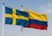 Flags of Sweden and Colombia waving together.