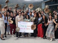 Insight Global professionals posing outdoors on a rooftop terrace, holding traditional Colombian hats and a banner that reads 'Driven by Excellence. (Photo: Insight Global)