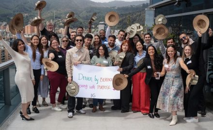 Insight Global professionals posing outdoors on a rooftop terrace, holding traditional Colombian hats and a banner that reads 'Driven by Excellence. (Photo: Insight Global)
