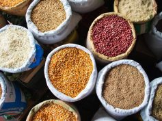 Open sacks of corn, red beans, rice and other grains viewed from above at a market