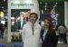 Daniel Mitchell in a white Acoplásticos vest and Ana Garibello in a dark blazer standing at a plastics trade fair booth