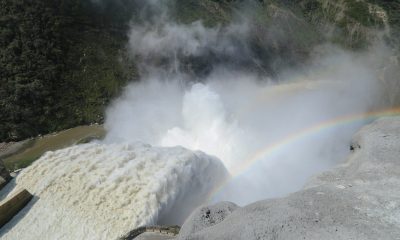 Water and mist pour through the spillway of the Hidroituango hydroelectric dam, with a rainbow in the spray