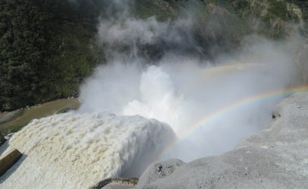 Water and mist pour through the spillway of the Hidroituango hydroelectric dam, with a rainbow in the spray