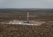 Aerial view of a drilling rig on a cleared well pad surrounded by scrubland in Vaca Muerta, Argentina