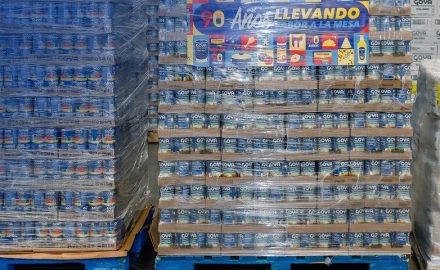Shrink-wrapped pallets of canned Goya tomato sauce and mixed vegetables stacked in a warehouse.