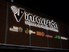 Illuminated Inravision public media system sign on its Bogota headquarters at night