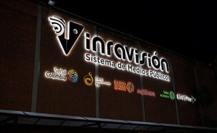 Illuminated Inravision public media system sign on its Bogota headquarters at night