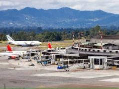Aerial view of the José María Córdova International Airport terminal and apron in Rionegro, with mountains behind