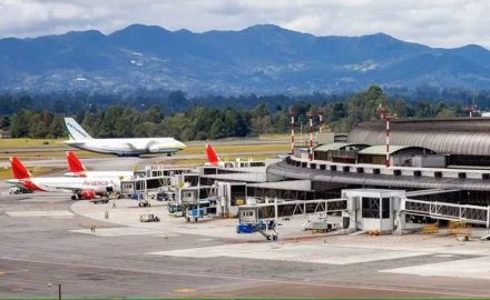 Aerial view of the José María Córdova International Airport terminal and apron in Rionegro, with mountains behind