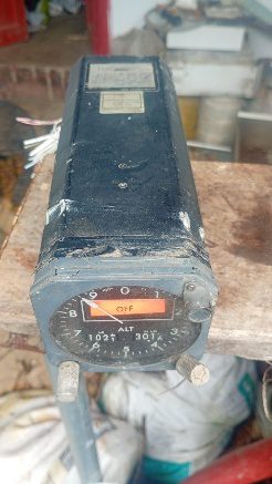 Worn aircraft altimeter instrument resting on a wooden table