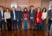 Nine people in business attire stand in a row before a wood-paneled wall with Colombia's coat of arms and the MinTIC name.
