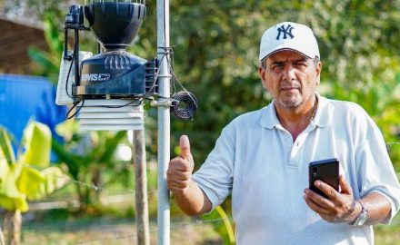 A man with his phone and a 5G pole. Courtesy of Mintic