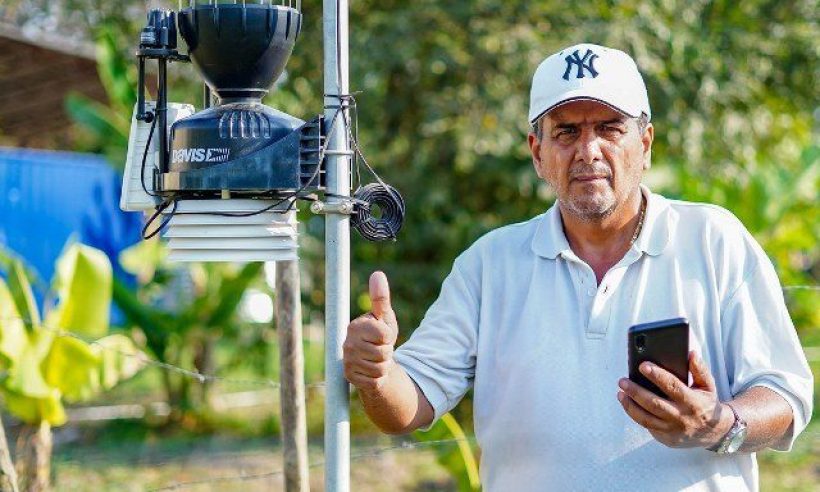 A man with his phone and a 5G pole. Courtesy of Mintic