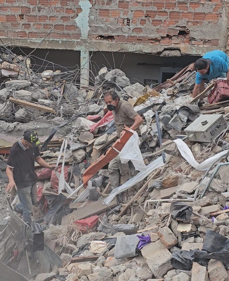 Volunteers search through rubble at a collapsed building following the Pereira earthquake.