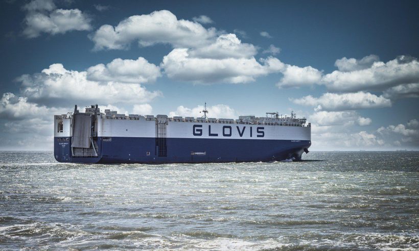 A car is driven aboard a ferry at a port.