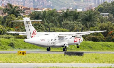 Clic ATR turboprop HK-5315 touching down on the runway at Olaya Herrera Airport, with Medellín hillside homes behind