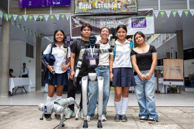 Five young people pose with a humanoid robot and a robot dog under SENA banners