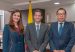 Commerce Minister Mauricio Gómez Amín stands between a woman and a man wearing a Mazda lapel pin in an office.