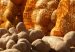 Potatoes piled in front of orange mesh sacks of potatoes