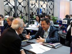Business representatives talk across numbered tables at a trade fair matchmaking session with ProColombia table signs