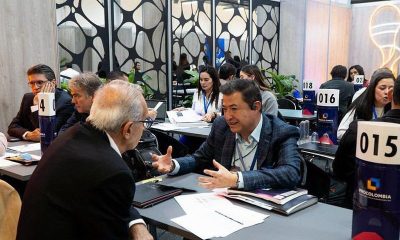 Business representatives talk across numbered tables at a trade fair matchmaking session with ProColombia table signs