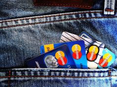 Credit and debit cards tucked into the back pocket of a pair of jeans.