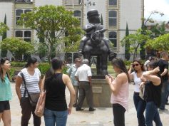 Visitors gather around Fernando Botero's bronze Hombre a caballo in Plaza Botero, Medellín.