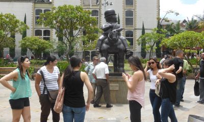Visitors gather around Fernando Botero's bronze Hombre a caballo in Plaza Botero, Medellín.
