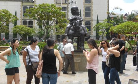 Visitors gather around Fernando Botero's bronze Hombre a caballo in Plaza Botero, Medellín.