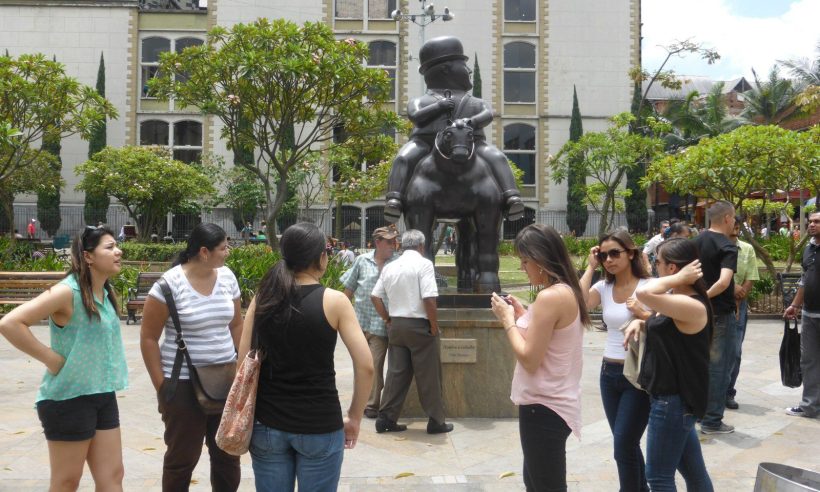 Visitors gather around Fernando Botero's bronze Hombre a caballo in Plaza Botero, Medellín.