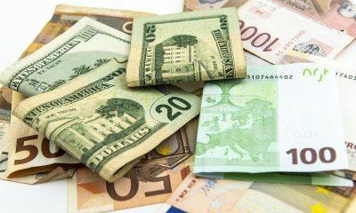 US $20 bills resting on euro and other foreign banknotes