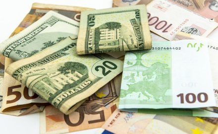US $20 bills resting on euro and other foreign banknotes